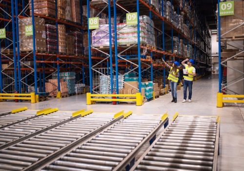 warehouse-workers-checking-inventory-goods-distribution-large-storehouse_342744-1482